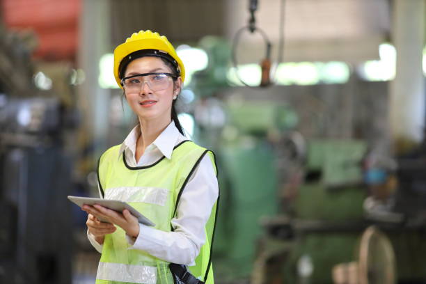 istock Asian engineering manager in safety hard hat and reflective cloth is inspecting inside the factory using digital tablet 1300759699