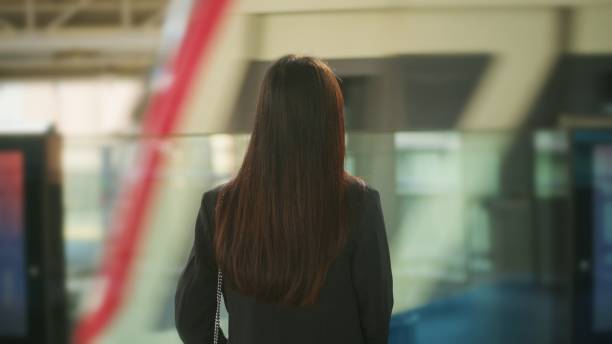 istock Young business woman is standing on metro platform, back side. 1300759728