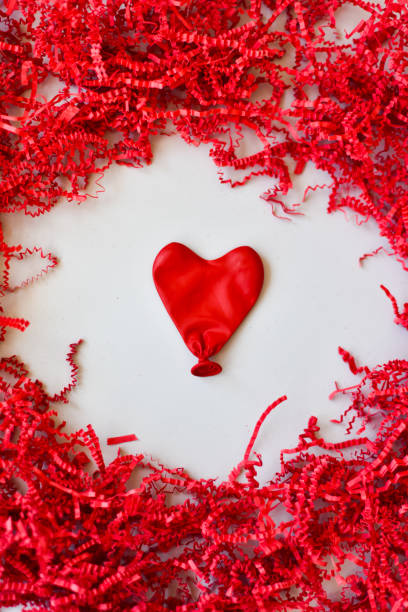 istock Messy Love - Red Heart Surrounded by Red Confetti 1300763088