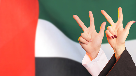 UAE National day - 3 fingers sign of Sheikh Mohammed bin Rashid, with UAE Flag on the background. patriotism concept