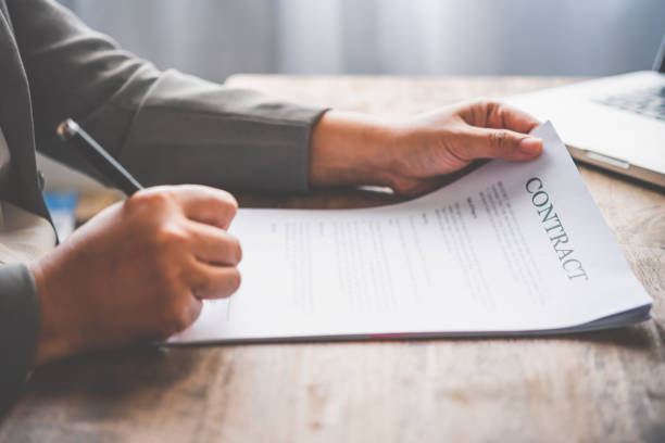 istock Hand holding pen signing contract in important documents. 1300768835