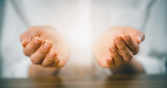 Manos de mujer rezando (hace una súplica) y ligeras en la palma de la mano. photo