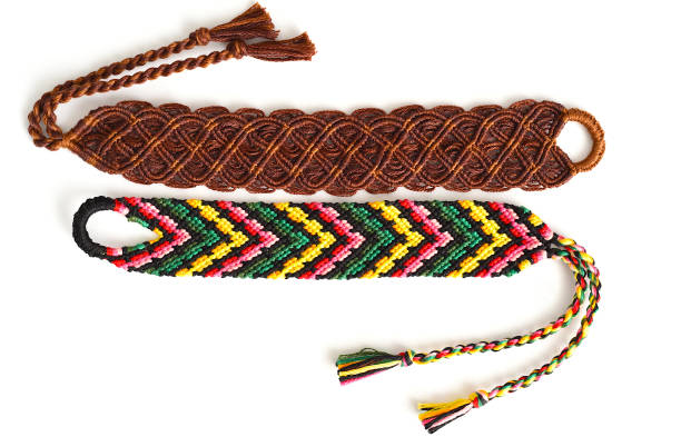 istock Woven friendship bracelets with bright colorful pattern handmade of thread on white background 1300772574
