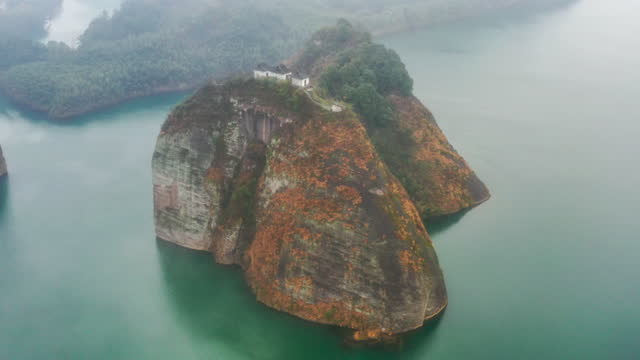 Three Taoist temples stand on the cliff island in the river