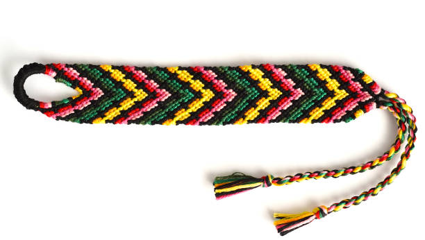 istock Woven friendship bracelet with bright colorful pattern handmade of thread on white background 1300773295