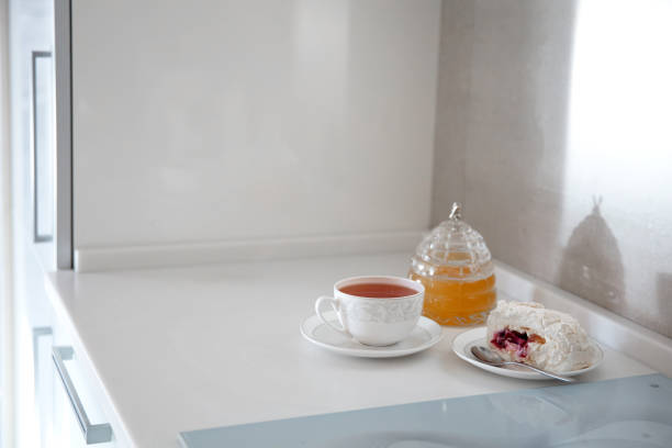 Kitchen table top, a cup of tea, kettle, honey, dessert on the table top. Mockup, template. Empty space for household appliances.
