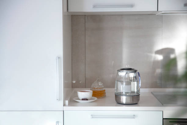 Kitchen table top, a cup of tea, kettle, honey, dessert on the table top. Mockup, template. Empty space for household appliances.
