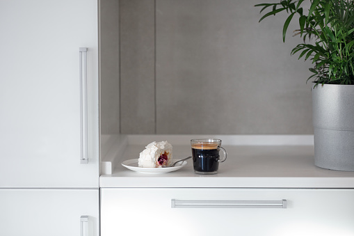 Stylish white kitchen table top. Cup of coffee, americano and espresso, sugar, dessert on the tabletop. Mockup, template. Empty space for household appliances. Empty tabletop.
