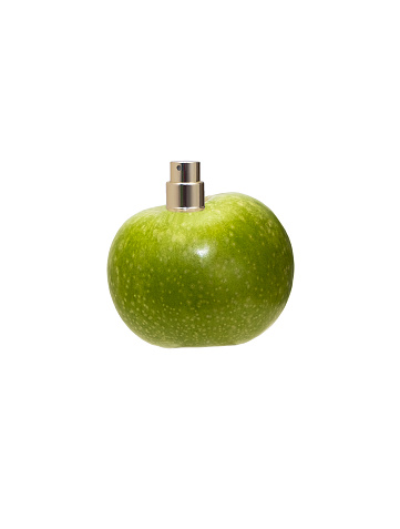 Juicy, green apple with a dispenser for perfume on a white background. Fruity aroma in perfumery, isolated object.
