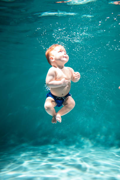söta kid dyker i poolen. kopiera utrymme - baby swim under water bildbanksfoton och bilder