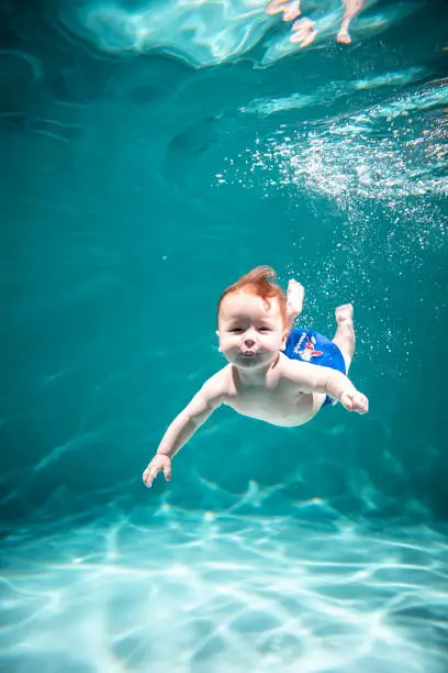 Photo of Cute Kid Dives in the Pool. Copy Space