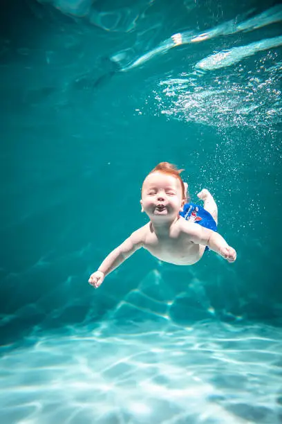Photo of Cute Kid Dives in the Pool. Copy Space