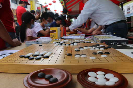 Masked people playing the Chinese Go Game, Weiqi in a street of Georgetown, Malaysia while Festival and Chinese New Year celebration, February 2, 2020
