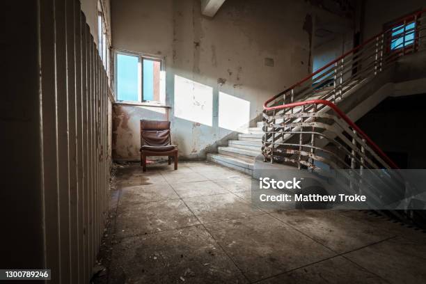 Abandoned Building Dark Staircase In Run Down Old Hospital School With Lone Chair Stock Photo - Download Image Now