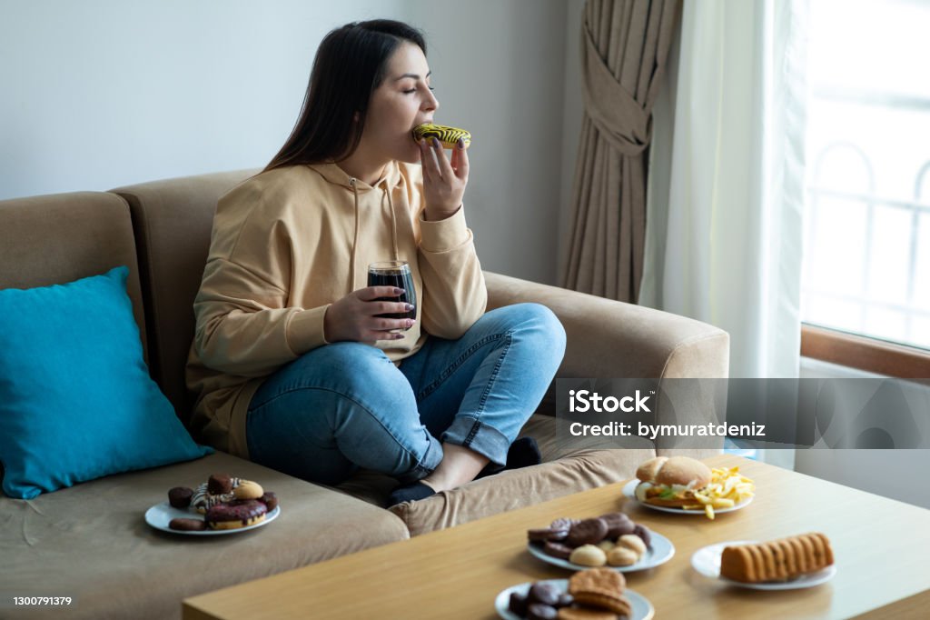 Eating sugary food on sofa Eating Stock Photo