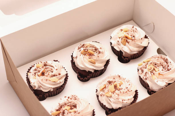 istock Six chocolate brownies with white cream on top on a white plate. Studio photo at an angle 1300792298