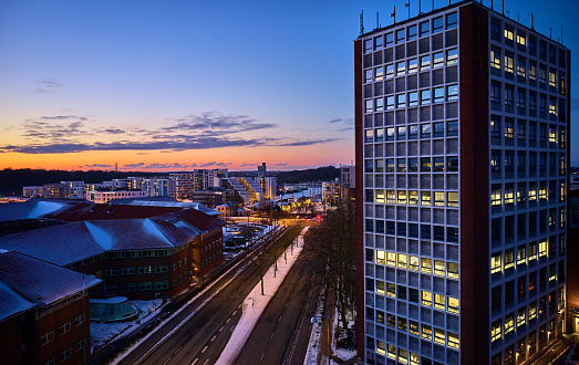Tall building near Odense Harbor blue hour light. Aerial drone shots. Odense city by night