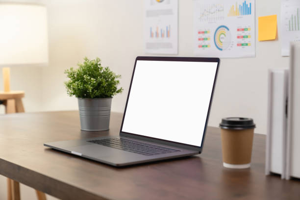 istock Laptop with blank screen on table in modern office. Mockup of advertisement. 1300793603