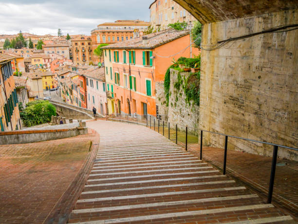 perugia, vista pitoresca do aqueduto medieval, rua de pedestres cercada por casas coloridas, região da úmbria, centro da itália - landmarks roof staircase landscape - fotografias e filmes do acervo