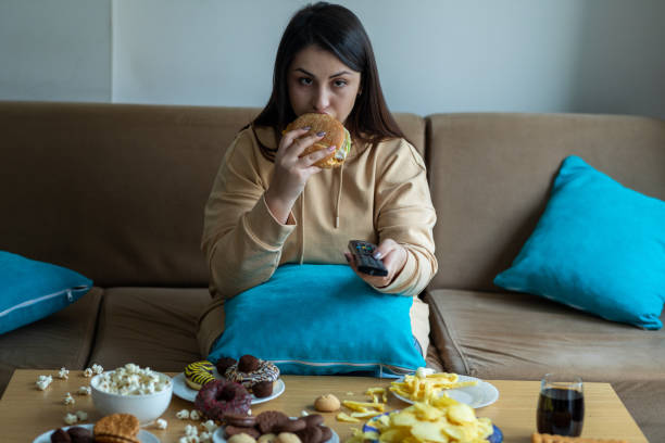 istock Overweight woman sitting on sofa 1300798110