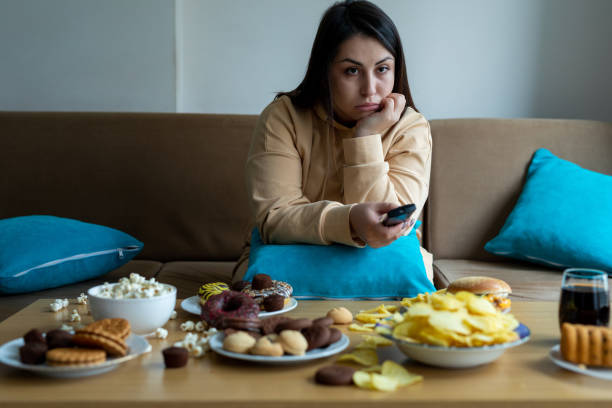 istock Overweight woman sitting on sofa 1300798136