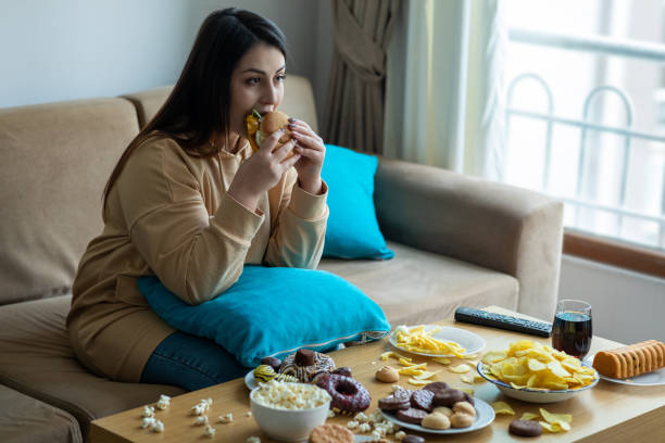 istock Overweight woman sitting on sofa 1300798165