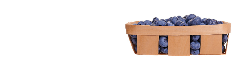 Fresh raw blueberry in wooden basket.