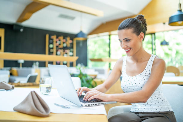 istock Smiling women sitting in restaurant and using laptop 1300804252