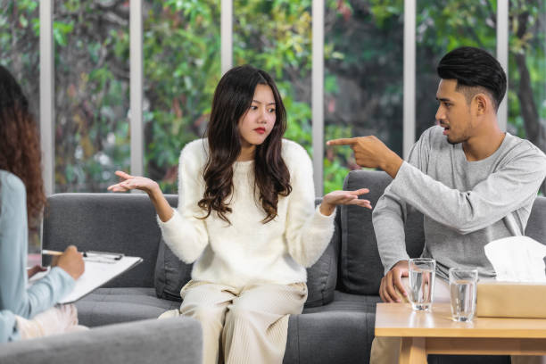 istock Rear view of coach listening and looking Asian young lovers Arguing about their problem, Psychologist couple and hypnosis concept, deny and argue,life coach and coaching in private indoor home concept 1300805232