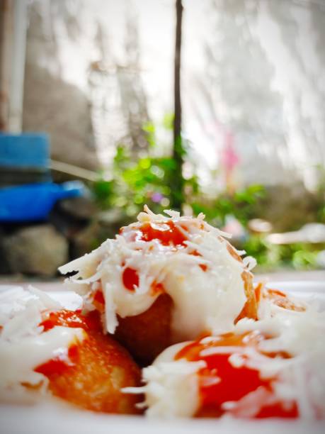 Takoyaki Takoyaki is the name of a food from the Kansai region of Japan, in the form of small balls with a diameter of 3-5 cm made from a flour dough filled with octopus pieces in it. cooking takoyaki is a ball shaped japanese snack stock pictures, royalty-free photos & images