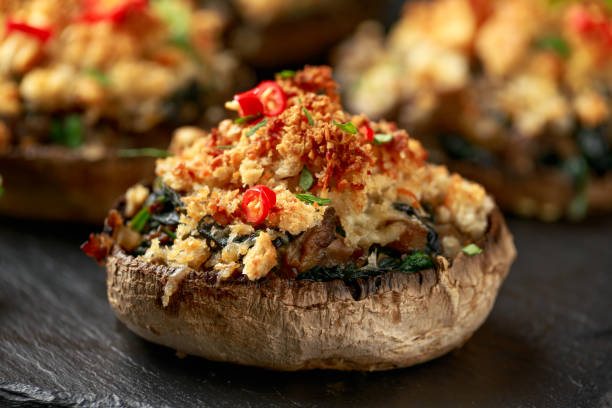 istock Stuffed mushrooms with spinach, bread crumbs and cheese on stone board 1300809444