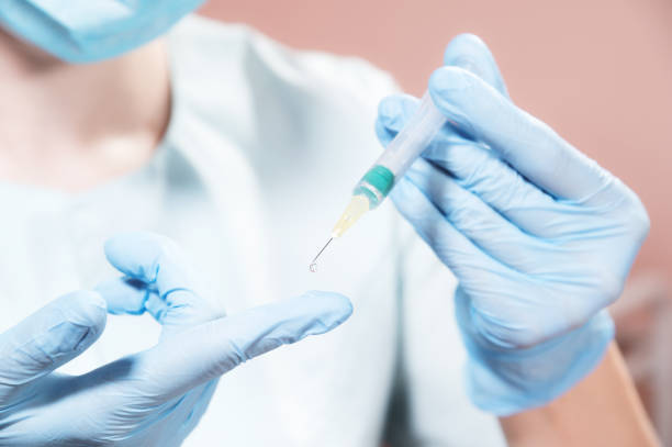 istock A doctor wearing a protective mask makes a test drop on a glove from a syringe. Vaccine and test in humans 1300809882