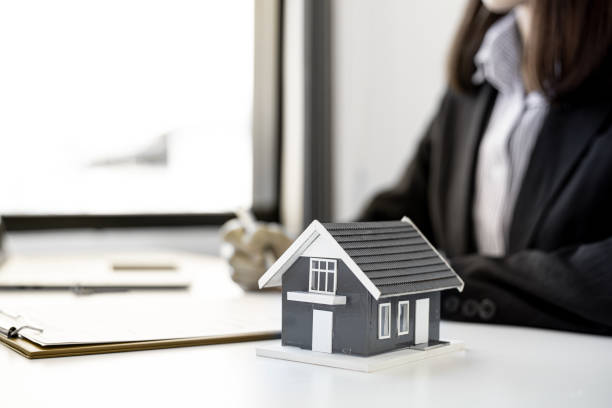 istock A small gray house model is placed on a desk in the housing project's sales office. 1300814254
