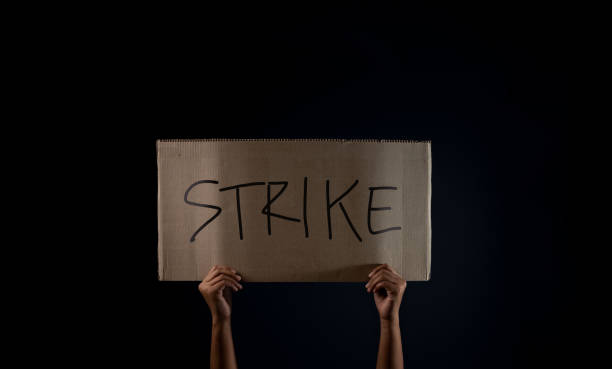 istock Protest , Strike, Mob or Expression Concept. Person Raised a Corrugated Paper with Text. Front View and Dark tone 1300815101