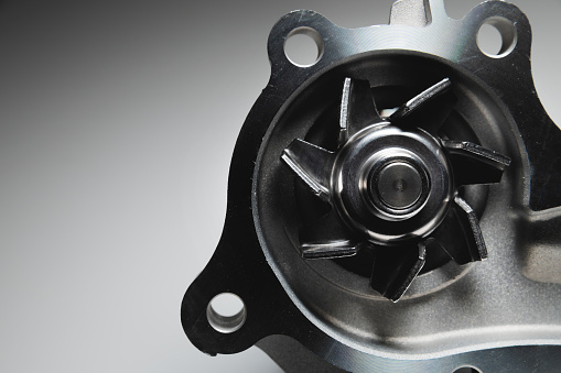 Engine coolant pump. New spare part on a contrasting gradient background for car services.