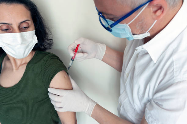 istock while getting vaccinated, vaccinating, doctor, hospital, vaccine, while the lady was getting vaccinated 1300815624