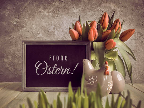 弗羅赫·奧斯特恩在德語中用英文的意思是復活節快樂。復活節或春季生日慶祝活動。一束鬱金香和陶瓷母雞與雞蛋在木材上 - ostern 個照片及圖片檔