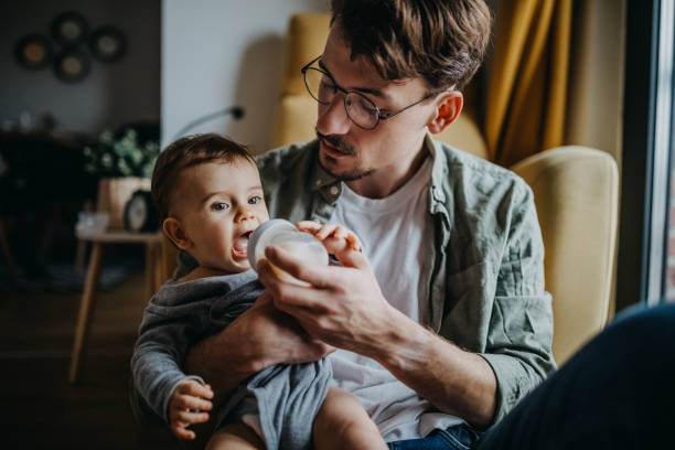 istock Father feeding his son in hight chair 1300816421