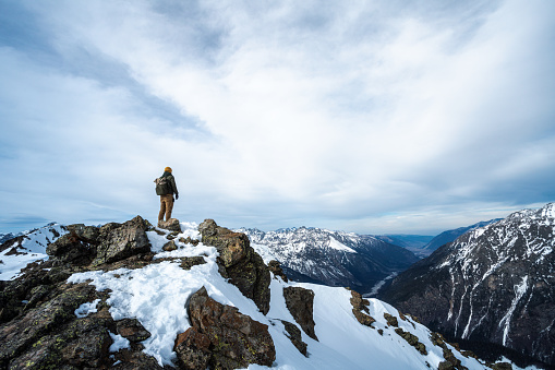 Woman backpacker hiking in winter high altitude mountains