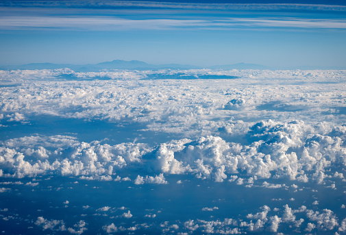 Cloudscape and Landscape. Flying above the clouds, aerial view from the airplane.
