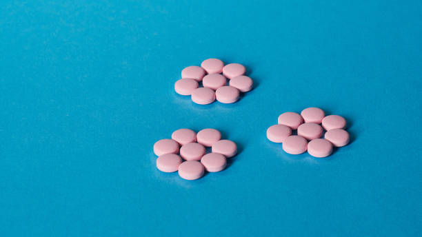 istock Pink pills on a blue background 1300819092