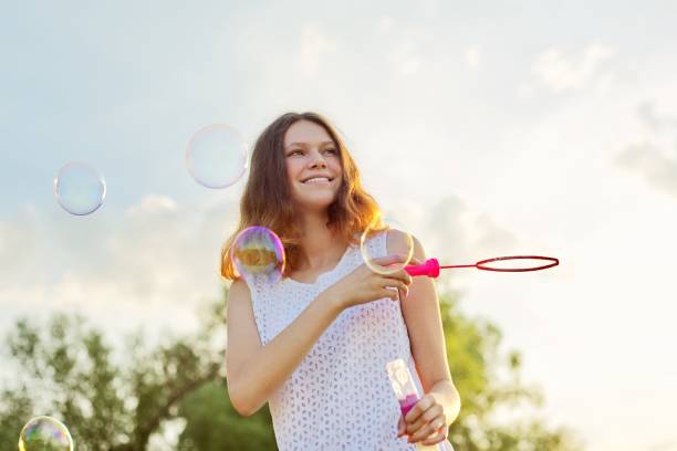 happy cheerful smiling girl teenager 15, 16 years old with soap bubbles - teenager 14 15 years 13 14 years cheerful imagens e fotografias de stock