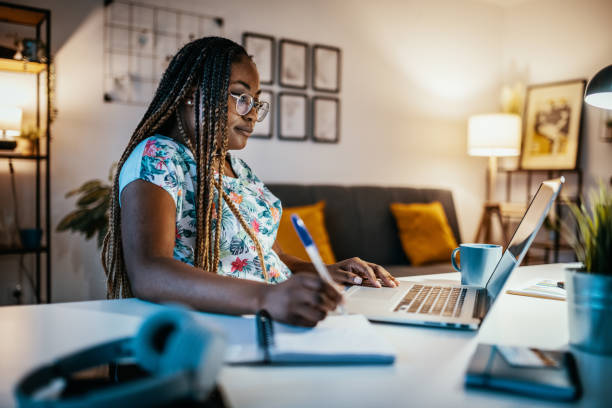 African American female student studying from home and taking notes from professor African American female student studying from home during lockdown homework stock pictures, royalty-free photos & images