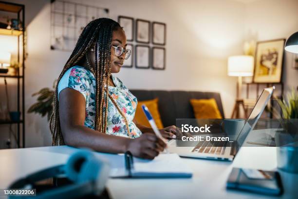 African American Female Student Studying From Home And Taking Notes From Professor Stock Photo - Download Image Now