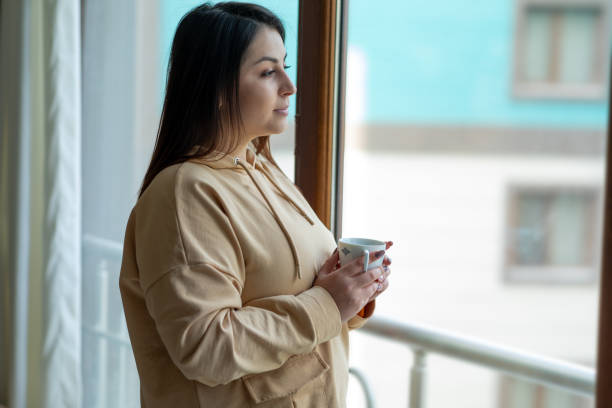 woman standing near window