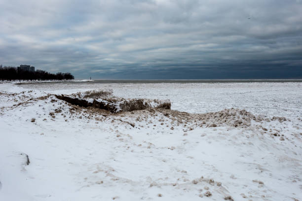 gelo congelado e areia forrando a borda do lago michigan no dia frio do inverno com céu nublado - bizarre landscape sand blowing - fotografias e filmes do acervo