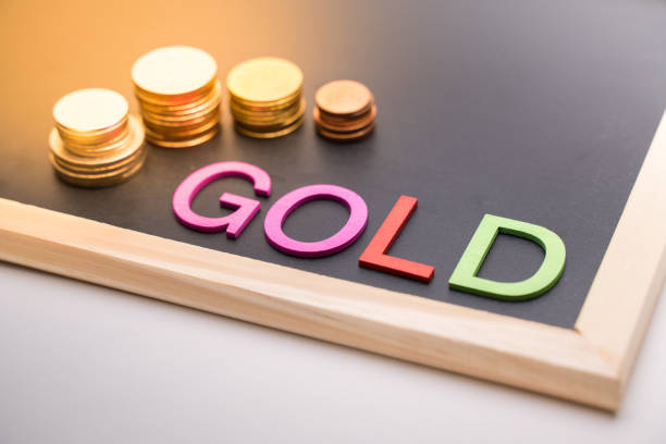 istock Gold text on blackboard beside coin and light 1300823691
