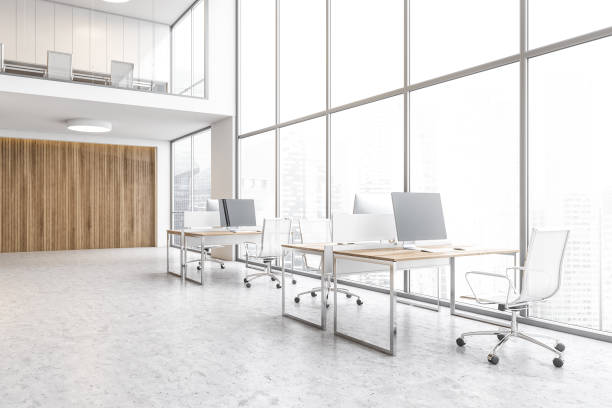 istock Tables with computers near big window, skyscrapers view open space lobby 1300824635