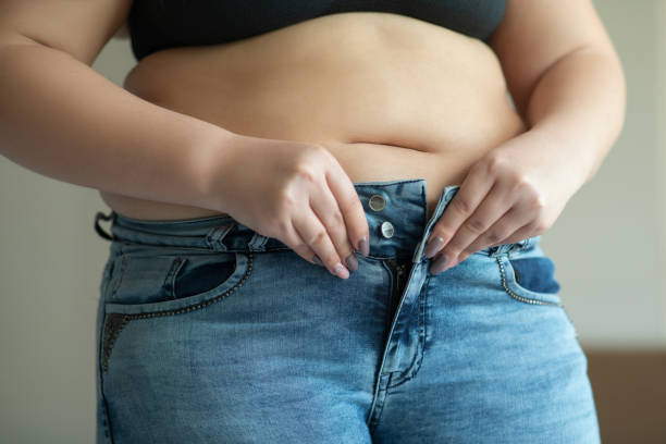 tentando usar jeans apertados - abdomen too small jeans overweight - fotografias e filmes do acervo