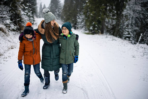 istock Kids enjoying hiking in winter forest. 1300827647